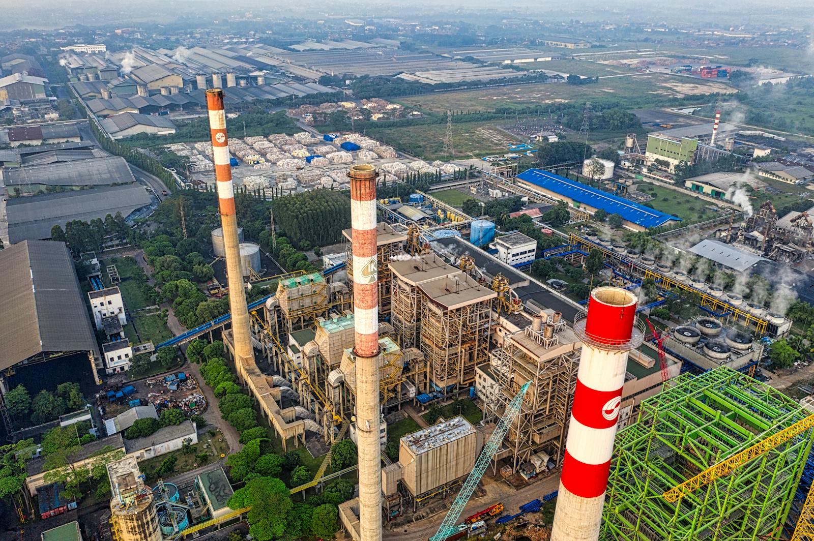 Aerial shot of a large industrial plant in Serang, Indonesia, showing smokestacks and cityscape.